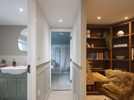 A hallway with a sink and bookshelf at Rock View Trethurgy near St Austell