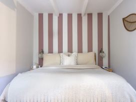 A bedroom with a bed and striped walls at Rock View Trethurgy near St Austell