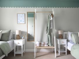 A bedroom with two beds and a hanging rack at Rock View near Trethurgy near St Austell