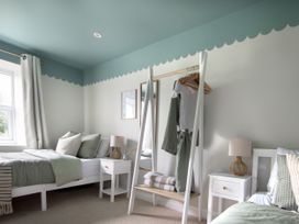 A bedroom with a bed and clothes rack at Rock View, Trethurgy near St Austell