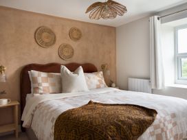 A bedroom with a bed and wall art at Rock View in Trethurgy near St Austell