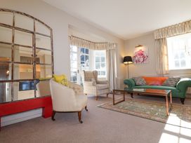 A living room with armchairs sofa coffee table and large window at Holm Oak Lodge in Tendring near Weeley