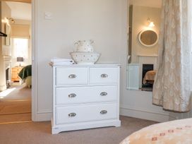 A white chest of drawers with a ceramic pitcher and bowl on top in a bedroom at Holm Oak Lodge in Tendring near Weeley