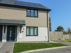 A house with solar panels and a lawn at 36 Parc Delfryn