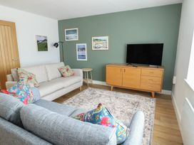 A living room with a television and a sofa at 36 Parc Delfryn