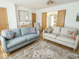 A living room with sofas and a rug at 36 Parc Delfryn 