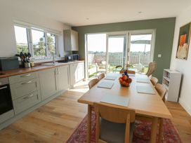 A kitchen with a dining table and chairs at 36 Parc Delfryn