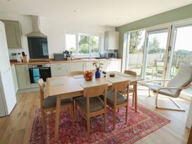 A kitchen with a dining table and chairs at 36 Parc Delfryn