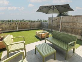 A garden with outdoor furniture and a patio umbrella at 36 Parc Delfryn