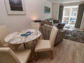A living room with a table and chairs, a sofa, and artwork at The Trick in Carbis Bay