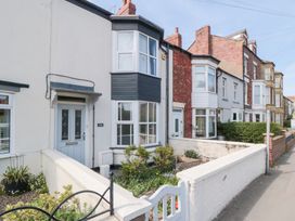 Row of terraced houses with small front gardens and low walls along a street