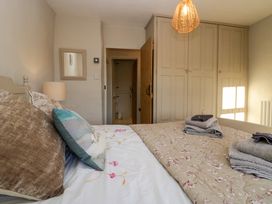 A bedroom with a bed with pillows and towels with built in wardrobes and an open door at Holme Fell View in Sedbergh