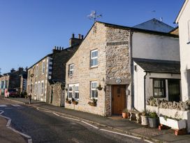 A street with stone and white cottages and flower pots at Holme Fell View in Sedbergh