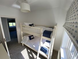 A bedroom with a bunk bed and window with patterned blind at 12 Thurlestone Rock in Thurlestone