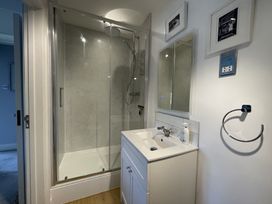 A bathroom with a glass shower enclosure a white vanity with sink and mirror above at 12 Thurlestone Rock in Thurlestone