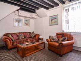A living room with two brown leather sofas and a wooden coffee table at The Courtyard Cottage in Llangollen