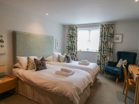 A bedroom with two beds and an armchair at 22 Dart Marina Dartmouth