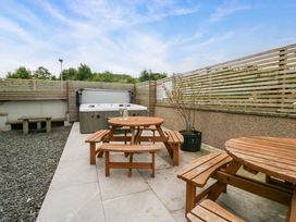 An outdoor area with a hot tub and table at Lund House Ulverston
