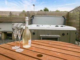 An outdoor area with a hot tub and a table with champagne at Lund House in Ulverston