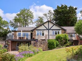 A house with a balcony and garden at The Old Barn in Pentre Celyn