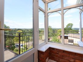 A conservatory with a view of the garden at The Old Barn in Pentre Celyn