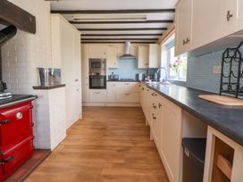 A kitchen with cabinets and appliances at The Old Barn in Pentre Celyn