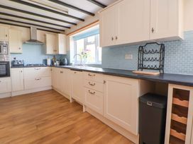 A kitchen with cabinets and sink at The Old Barn in Pentre Celyn