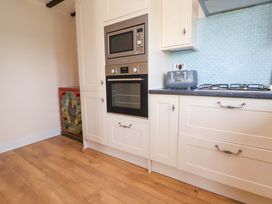 A kitchen with an oven and microwave at The Old Barn in Pentre Celyn