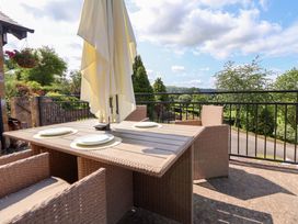 An outdoor dining area with a table and umbrella at The Old Barn in Pentre Celyn