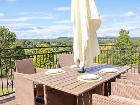 A dining table with chairs and an umbrella at The Old Barn in Pentre Celyn