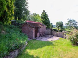 A garden with a shed and fenced area at The Old Barn in Pentre Celyn