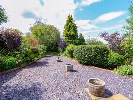 A garden with gravel path and plants at The Old Barn in Pentre Celyn