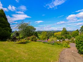 A garden with trees and flowers at The Old Barn in Pentre Celyn