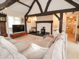 A living room with a fireplace and television at The Old Barn in Pentre Celyn