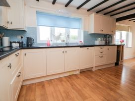 A kitchen with cabinets and sink at The Old Barn in Pentre Celyn