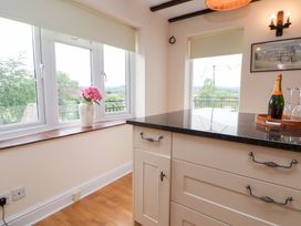 A kitchen with windows and a flower pot at The Old Barn in Pentre Celyn