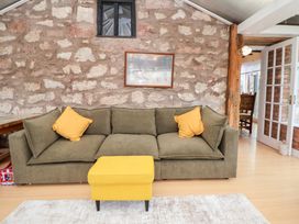 A living room with a sofa and ottoman at The Old Barn in Pentre Celyn
