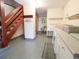A utility room with a sink and washing machine at The Old Barn in Pentre Celyn