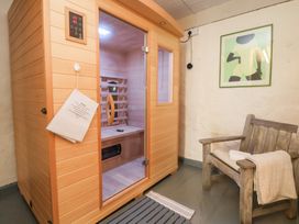 A sauna with a chair and wall art at The Old Barn in Pentre Celyn