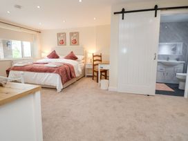 A bedroom with a bed and ensuite bathroom at The Old Barn in Pentre Celyn