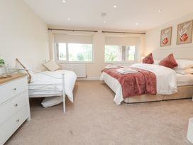 A bedroom with two beds and a wardrobe at The Old Barn in Pentre Celyn