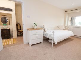 A bedroom with a bed and dresser at The Old Barn in Pentre Celyn