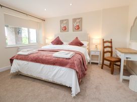 A bedroom with a bed and a chair at The Old Barn in Pentre Celyn