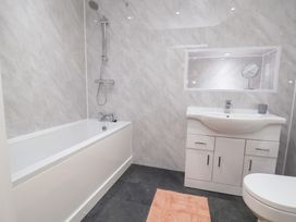 A bathroom with a bathtub, shower, sink and toilet at The Old Barn in Pentre Celyn