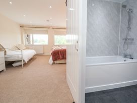 A bedroom with a bathtub visible at The Old Barn in Pentre Celyn
