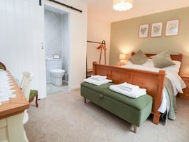 A bedroom with a bed and adjoining bathroom at The Old Barn in Pentre Celyn