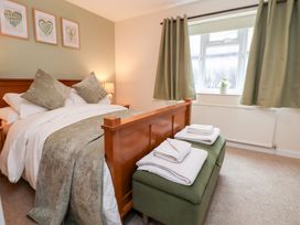 A bedroom with a bed and towels on a bench at The Old Barn in Pentre Celyn