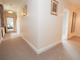 A hallway with doors and a mirror at The Old Barn in Pentre Celyn