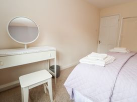 A bedroom with a bed and dressing table at The Old Barn in Pentre Celyn