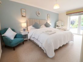 A bedroom with a bed and lamp at The Old Barn in Pentre Celyn